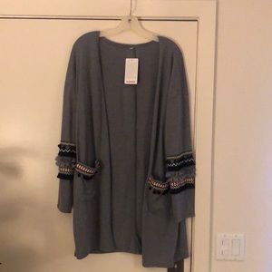Grey cardigan with ruffles and ball accents